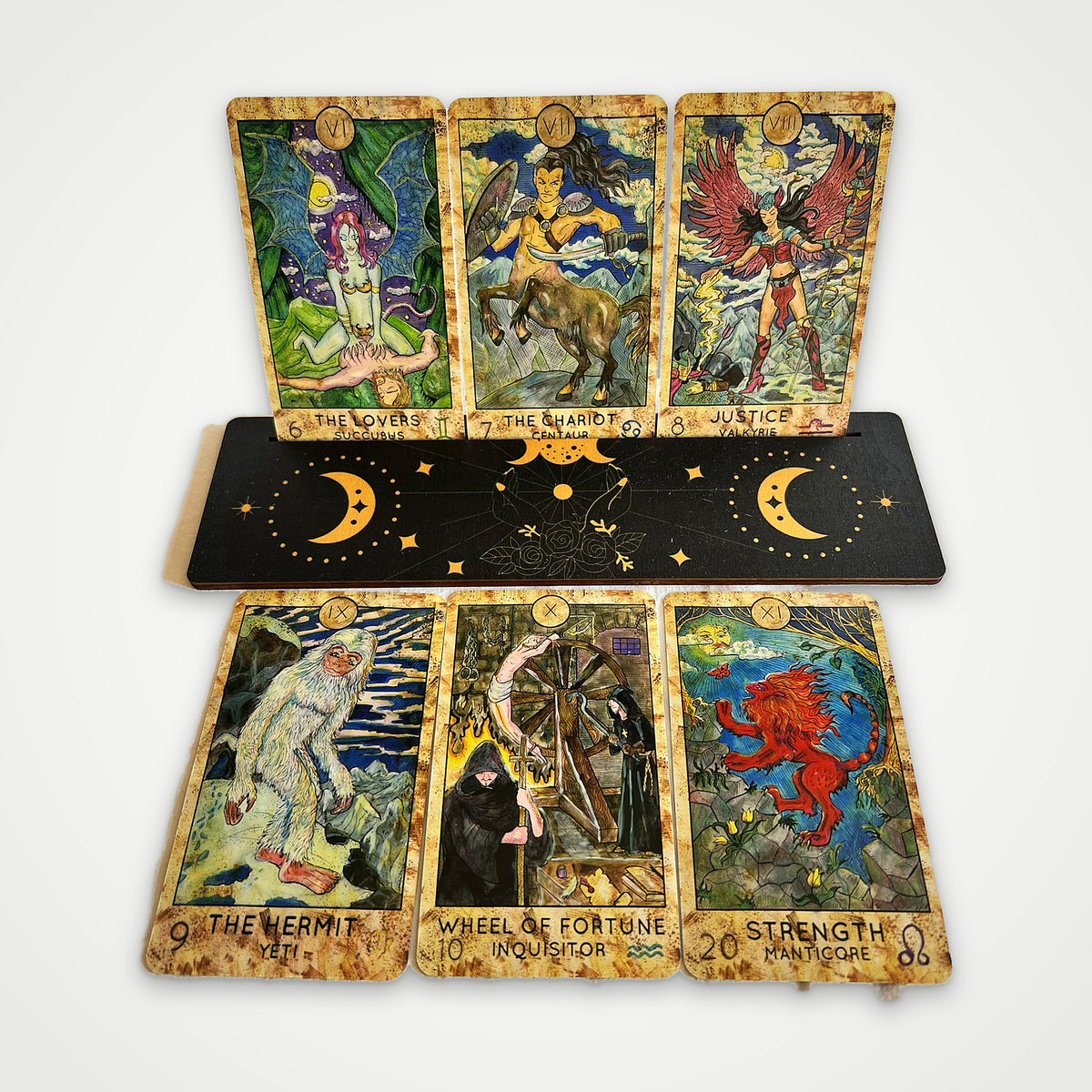 Fantasy World Tarot cards on a wooden stand: The Lovers, The Chariot, Justice, The Hermit, Wheel of Fortune, Strength