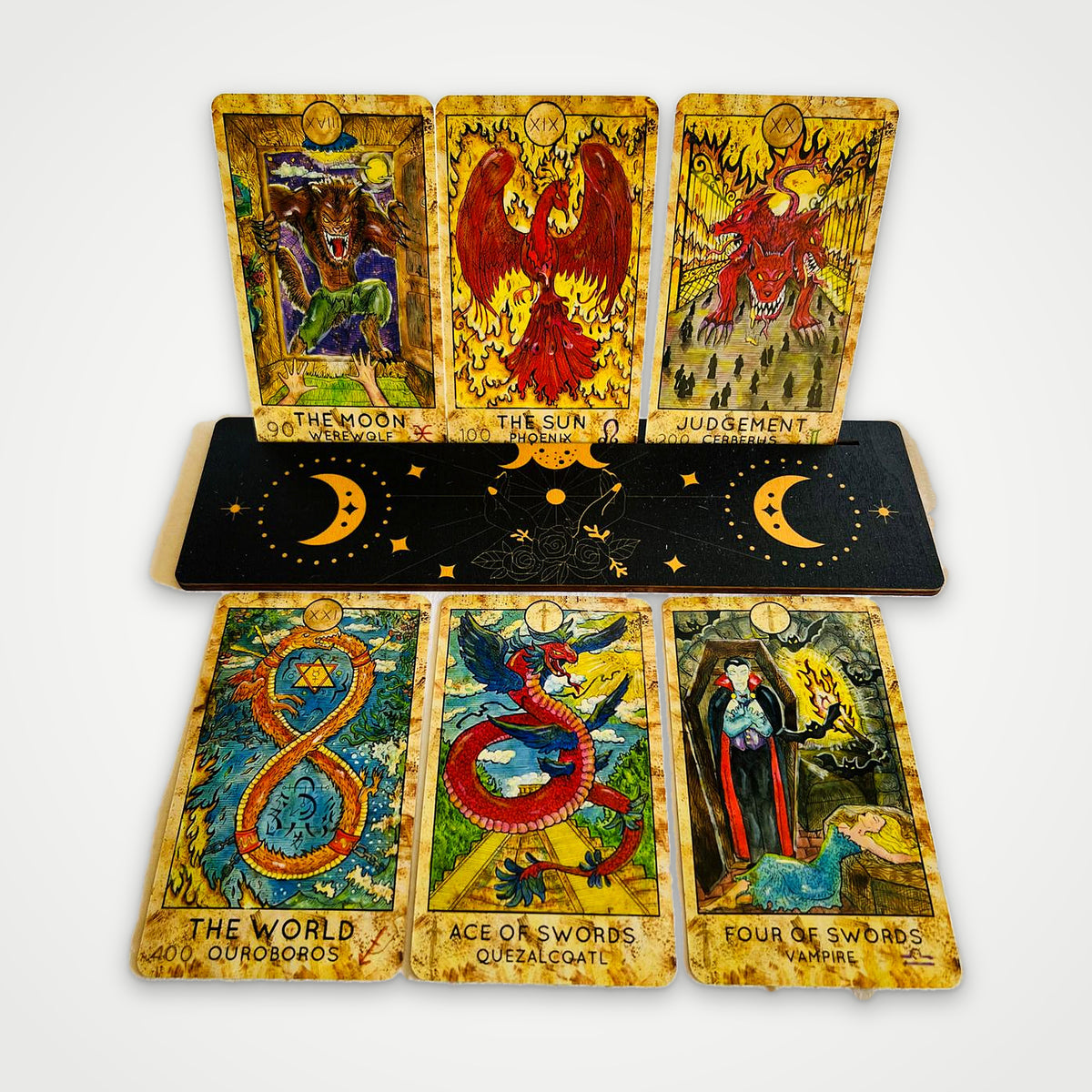 Fantasy World Tarot cards on a wooden stand: The Moon, The Sun, Judgement, The World, Ace of Swords, Four of Swords