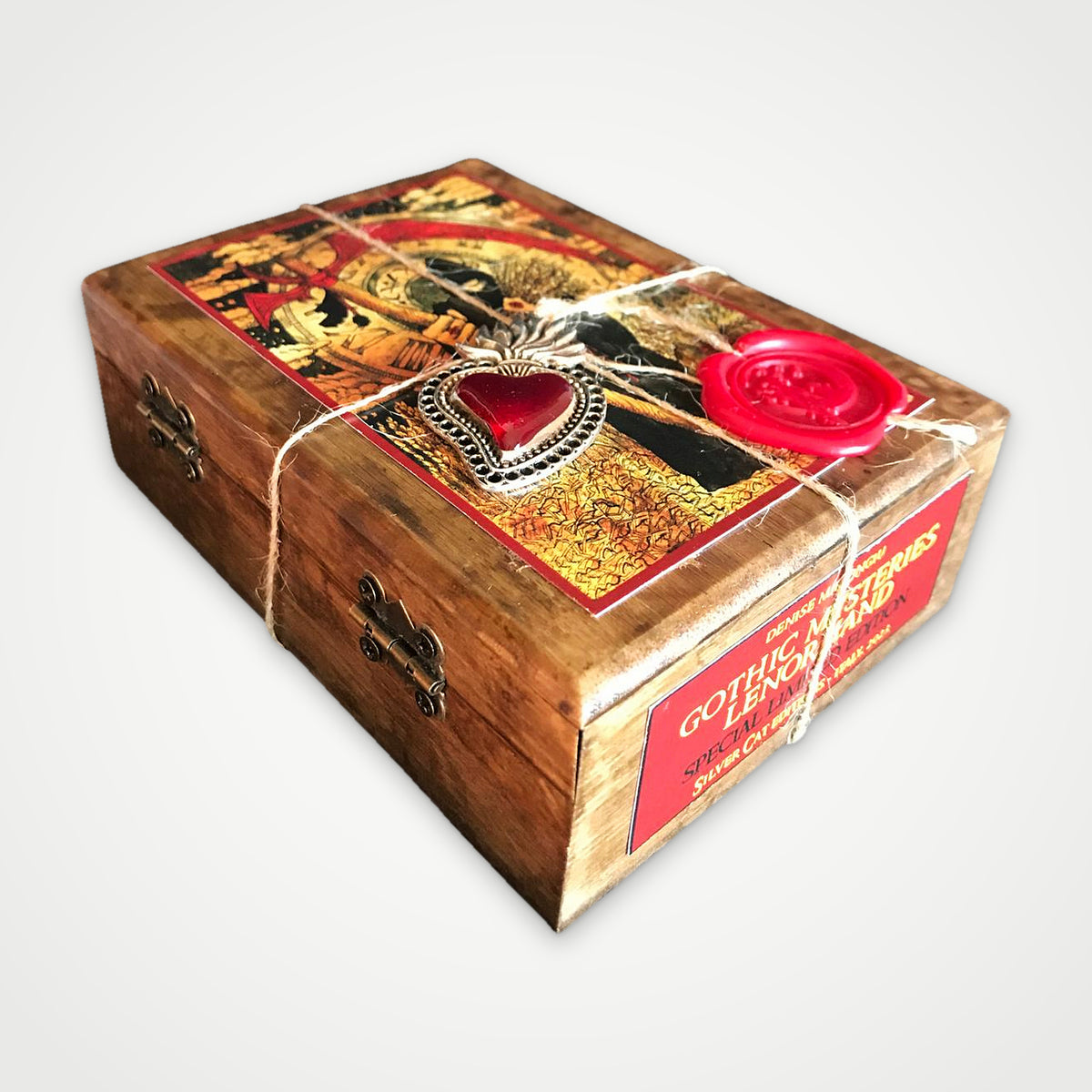 Brown wooden box with metal hinge and clasp, red label, twine, heart charm and wax seal