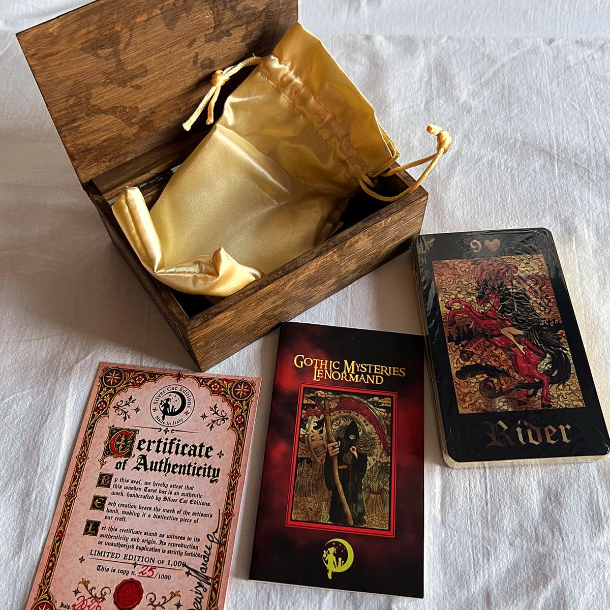 Open brown wooden box with golden satin pouch, certificate of authenticity, booklet and 36-card deck