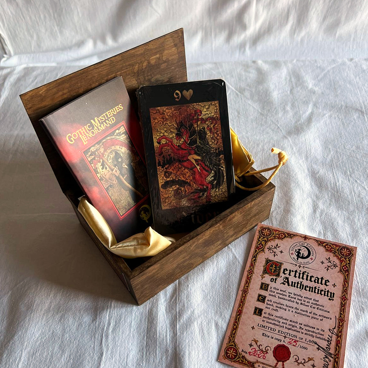 Open brown wooden box holding the booklet and the 36-card deck, with the numbered certificate of authenticity beside it