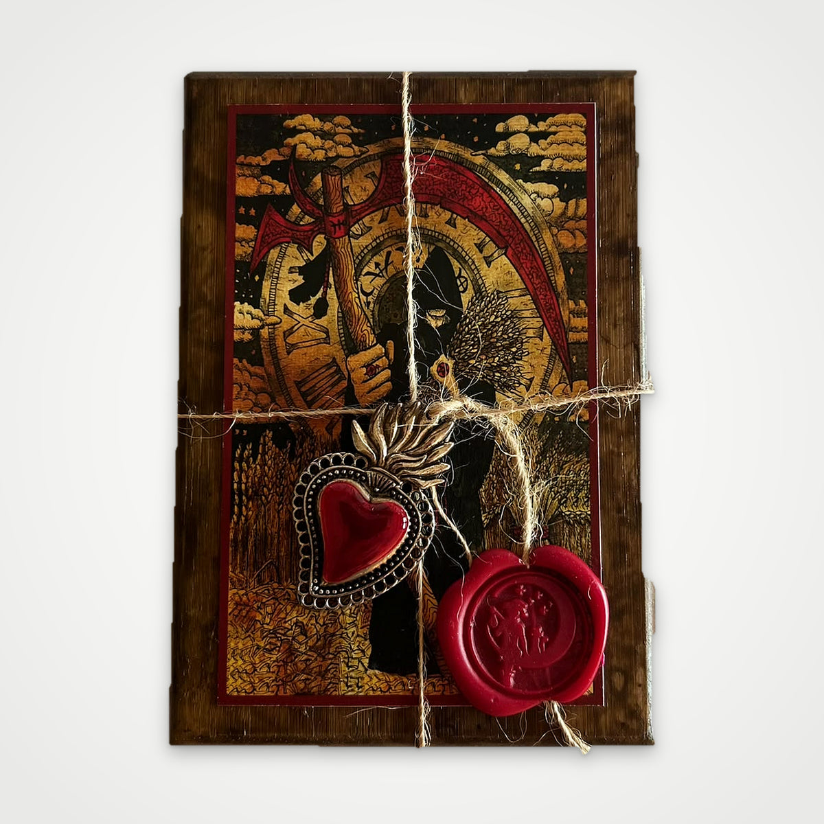 Top view of the brown wooden box with the Scythe artwork, twine, red wax seal and silver heart charm